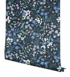 a blue floral wallpaper with white flowers and green leaves on the bottom half of it