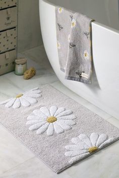 a white bath rug with daisies on it