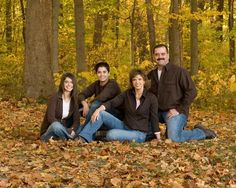 a family posing for a photo in the leaves