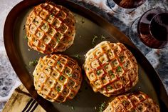 four waffles on a plate with wine glasses