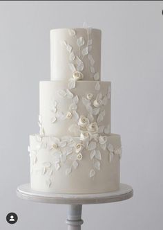 a three tiered cake with white flowers on it