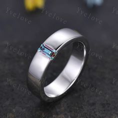 a white gold wedding ring with an aqua blue topazte stone in the center