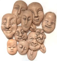 a group of clay faces sitting next to each other