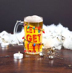 a beer mug sitting on top of a wooden table next to christmas lights and bells