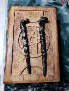 two black swords are in a wooden box