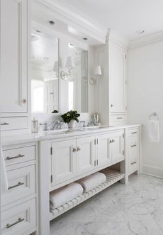 a bathroom with white cabinets and marble counter tops, along with an instagram for the photographer