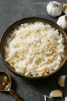 white rice in a bowl with garlic on the side