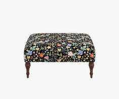 a foot stool covered in flowers on a white background