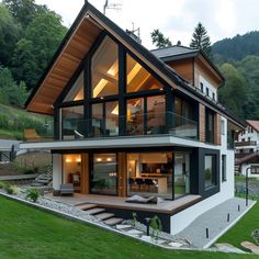 a modern house in the middle of a grassy area with stairs leading up to it