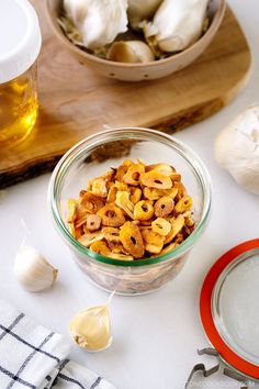 a bowl filled with pasta next to garlic and other ingredients on a cutting board,