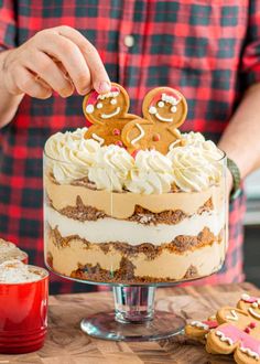 a man is decorating a cake with cookies and marshmallows on top