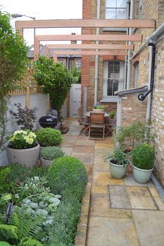 an outdoor patio with potted plants on the side and stairs leading up to it