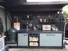 an outdoor kitchen with potted plants and cooking utensils