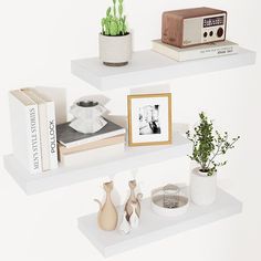 two white shelves with books and plants on them