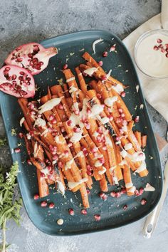 a platter filled with carrots and pomegranate next to a glass of milk