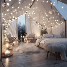 a bed sitting under a white tent covered in lights next to a table and chairs