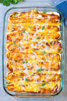 a casserole dish filled with cheese and vegetables on top of a blue towel