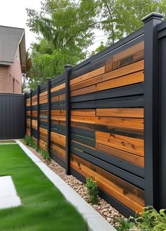 a wooden fence next to a lush green yard