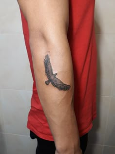 a man's arm with a bird tattoo on the left side of his arm