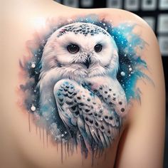 an owl tattoo on the back of a woman's upper arm, with blue and white paint splatters