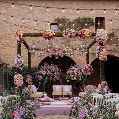 an outdoor ceremony with flowers and lights