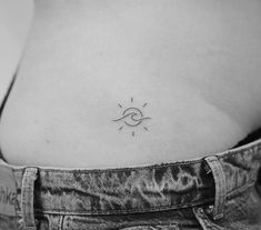 the back of a woman's stomach with an eye and sun tattoo on it