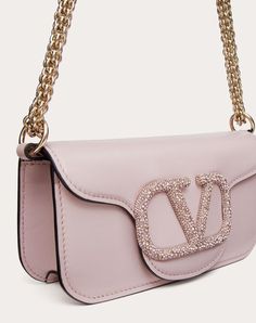 Valentino Garavani Locò small shoulder bag in calfskin with VLogo Signature element adorned with Swarovski® crystals. Equipped with a detachable sliding chain strap and a removable handle, this bag can be worn as a crossbody/shoulder bag or carried as a handbag. Palladium-finish hardware - Magnetic closure - Removable leather handle - Shoulder strap with removable sliding chain - Nappa leather lining. Interior: one slip pocket Shoulder strap drop length: 55 cm / 21.6 in. - Dimensions: W20xH11xD5 Magenta Bag, Logo Woman, Fashion Inspo Instagram, Jewel Logo, Valentino Bag, Bow Mules, Studded Sneakers, Oxford Boots, Valentino Bags