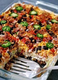 a large casserole with lots of toppings and a fork in the dish