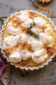 a pie topped with whipped cream on top of a wooden table