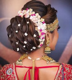 the back of a woman's head, with flowers in her hair and jewelry