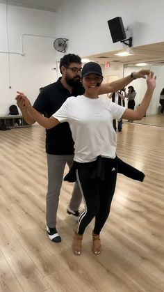 a man and woman dancing in a dance studio