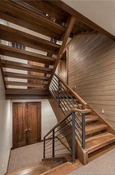 an empty room with stairs and wood paneling