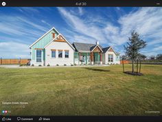 an image of a house in the middle of a field with blue skies above it