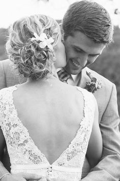 the bride and groom are looking at each other while they stand close together in black and white