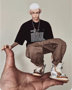 a man with white hair and glasses is sitting on top of a hand wearing sneakers