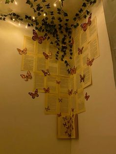 a book with butterflies on the pages and lights strung from it's back wall