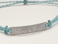 "This is an engraved waterproof bracelet, It is shown with an engraved brushed stainless steel bar and mint straps. You can choose your metal color and strap color. The bar will be engraved with \"Sisters in Christ\". You can choose back side engraving for personalization during checkout. Please let us know if you have any questions! The back can also be engraved. CHARACTER LIMIT- 14 characters per side Each item is made-to-order, which gives our pieces a unique meaning that is specific and spec Adjustable Engraved Name Bracelet For Friendship, Adjustable Name Bracelet With Engraved Text As Gift, Inspirational Engraved Adjustable Name Bracelet, Adjustable Stainless Steel Name Bracelet With Engraving Option, Inspirational Engraved Name Bracelet, Adjustable, Adjustable Stainless Steel Bracelets With Engraved Text, Adjustable Stainless Steel Bracelet With Engraved Text, Adjustable Silver Name Bracelet With Engraved Text, Inspirational Adjustable Silver Name Bracelet