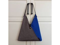 The royal blue zippered hobo bag is made of thick cotton, linen and polyester fabric, color is composed of dark blue, yellow and bej colors. The other side is made of saxe blue color fabric. Finished with black lining.  Handle and logo made of vegetable tanned leather in black. Inside is fully lined with 100% cotton black fabric, there are two pockets, one is open and the second is zippered.  Padded with felt fabric. As you can use your blue triangle bag with your jeans and sneakers, also you ca Vegan Tote Bag, Japanese Bag, Triangle Bag, Vegetable Leather, Zippered Bag, Blue Tote Bag, Denim Pocket, Blue Tote, Stylish Shoulder Bag