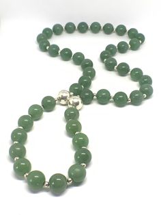 A '70s necklace of Chrysoprase gemstone beads interspersed with smaller silver colored beads. There are two silver colored magnet beads which contrast beautifully with the Kelly green gemstones. A lovely design feature. Chrysoprase is a powerful stone that brings good fortune and prosperity.... Emotionally, Chrysoprase is said to help heal a broken heart by providing a gentle boost to your self-esteem, equalizing emotional balance and fostering acceptance of change and tolerance for others. Chry Green Aventurine Beaded Necklace With Polished Beads, Green Aventurine Round Beaded Necklaces, Green Aventurine Beaded Necklaces, Green Aventurine Round Beaded Necklace, Green Aventurine Bead Necklace, Aventurine Polished Round Bead Necklaces, Aventurine Polished Round Beads Necklace, Polished Aventurine Bead Necklace, Green Aventurine Beaded Hand-strung Necklace