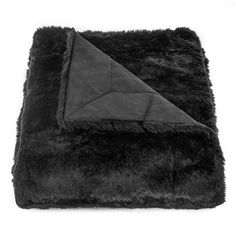 a blanket that is laying on top of a white surface with a black triangle in the middle