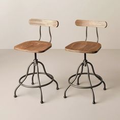 two wooden and metal stools sitting side by side