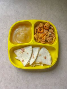 a yellow plastic plate filled with food on top of a table