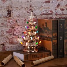 a small christmas tree sitting on top of a wooden table next to two corks