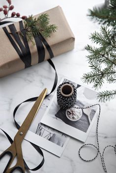 a present wrapped in black ribbon next to a pair of scissors