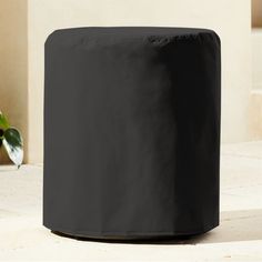 a black cover sitting on top of a table next to a potted plant