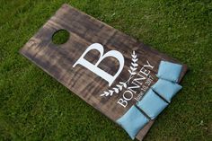 a cornhole board with blue pillows on the grass