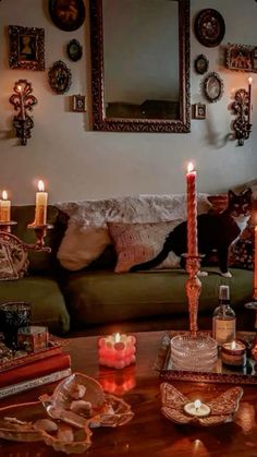 a living room filled with lots of candles on top of a wooden table next to a couch