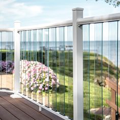 a deck overlooking the ocean with flowers in bloom