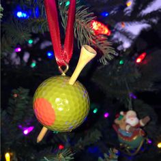 a golf ball ornament hanging from a christmas tree