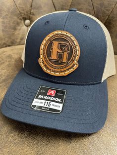 100% customized leather patch hats. We can put just about anything you want on them. All of our leather patches are hand drawn, some are tooled (according to preference) painted, and stitched onto our Richardson 112 or 115 (depending on the color).  Any questions on design/logo or hat colors you can message us prior to ordering. We can do company hats for your business also with bulk pricing.  Our turn around time is 2 weeks. When we get to your order we do send a draft for approval before continuing.  Each patch is glued and hand sewn onto the hat. Leather Patch Cap - Gift, Leather Patch Cap As A Gift, Leather Patch Cap As Gift, Leather Patch Cap Hat Gift, Leather Snapback Hat With Letter Patch, Custom Hat With Leather Patch And Flat Bill, Custom Flat Bill Hat With Leather Patch, Custom Flat Brim Hats With Leather Patch, Custom Trucker Hat With Leather Patch Snapback